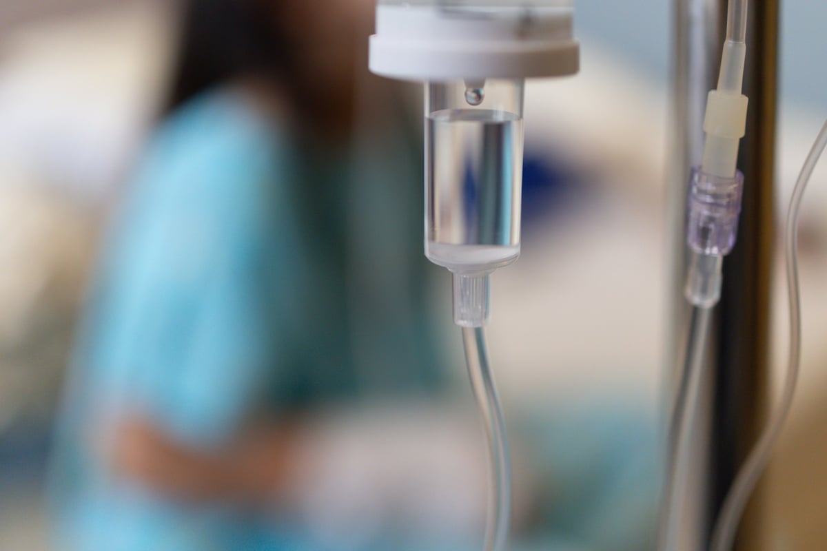 Three clear IV saline bags in a medical laboratory